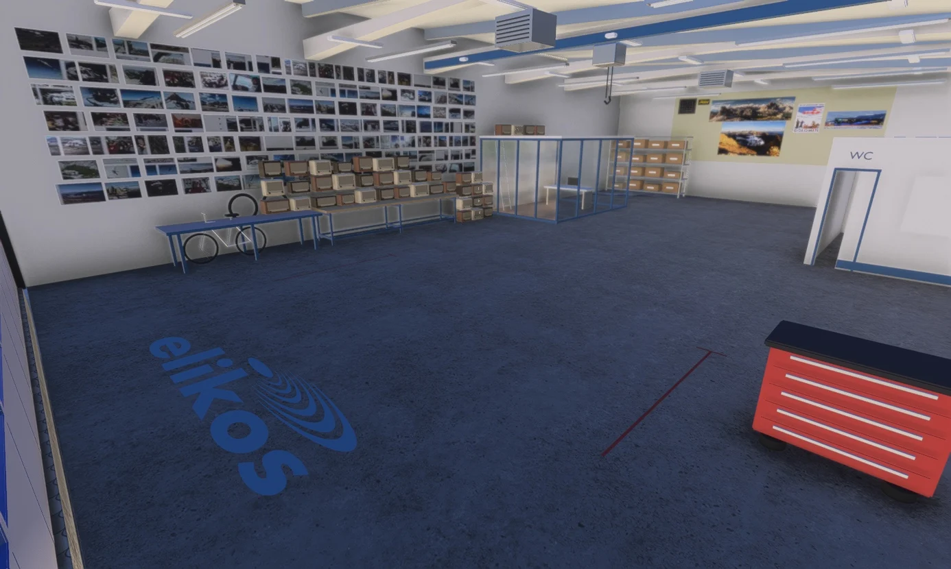 Elikos hangar interior with equipment, workbenches and a wall of photographs.