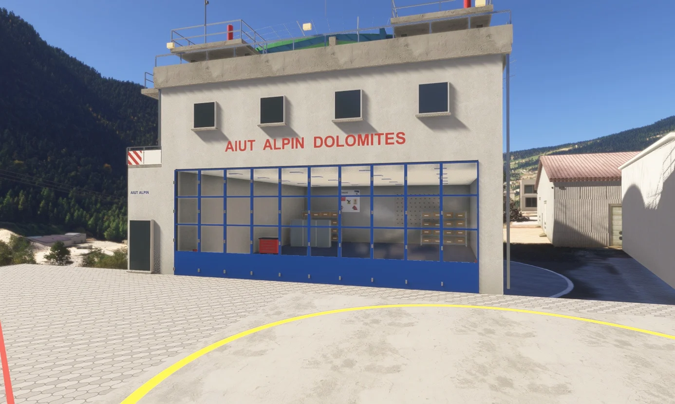 Blue glazed hangar doors and the Aiut Alpin Dolomites facade.