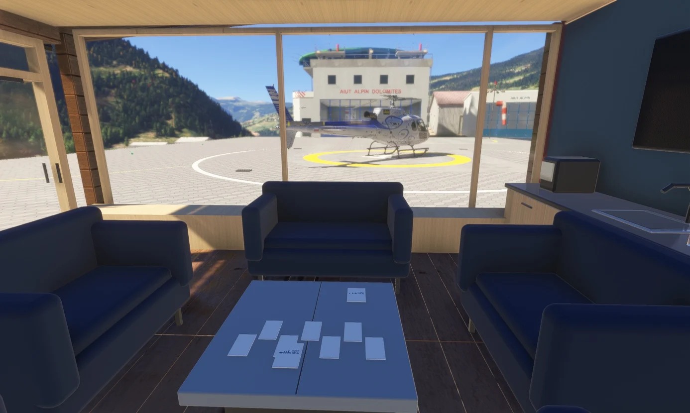 A helicopter and the Aiut Alpin hangar seen through the Elikos reception windows.